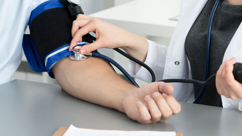 Ärztin misst Blutdruck ihres Patienten Ärztin misst Blutdruck ihres Patienten