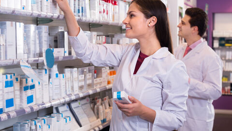 Apotheker räumen Regale in Apotheke ein Apotheker räumen Regale in Apotheke ein