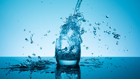 Spritzendes Trinkwasser in einem Wasserglas