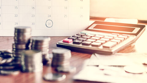 Münzen, Rechner auf dem Tisch